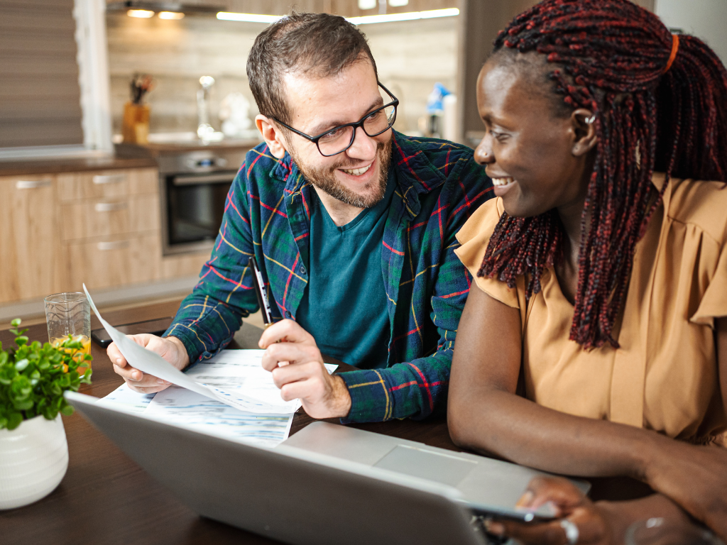Couple smiling while reviewing high ratio mortgage documents 