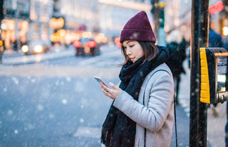 Woman Waiting to Cross Street Holding Phone
