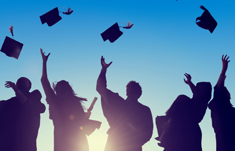 Five graduates tossing caps after ceremony