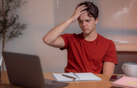 Student scratching his head after potential student loan forgiveness scam