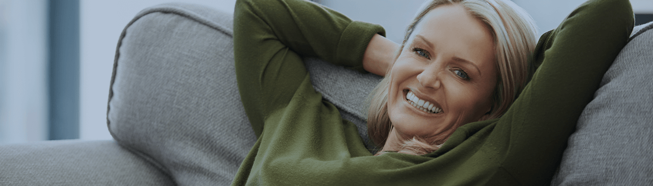 Woman Smiling While Relaxing on Couch