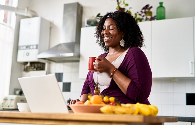 Woman Drinking Coffee at Kitchen Table