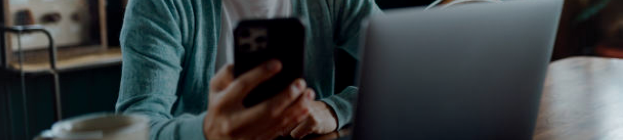 Person Using Mobile Phone and Laptop for Banking