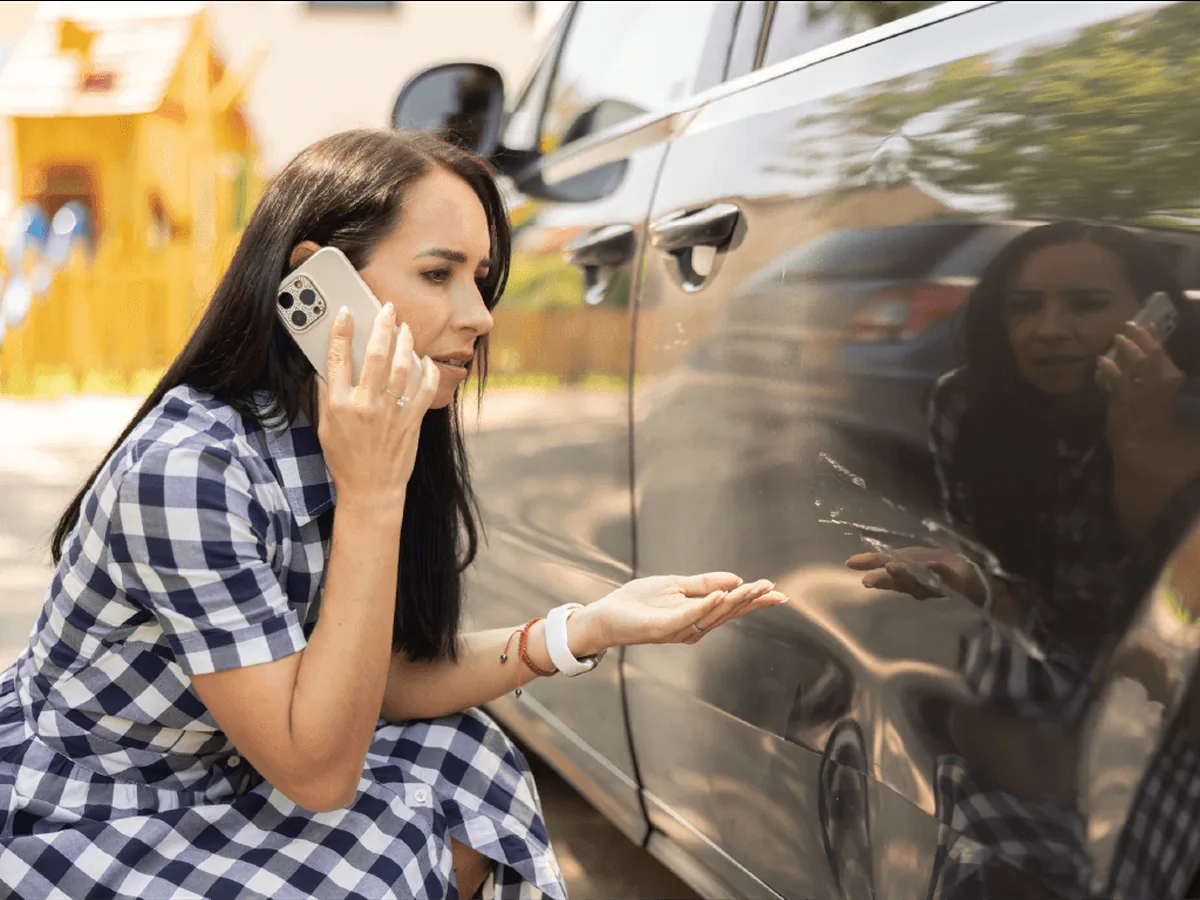 Woman on the phone with insurance agent after car accident