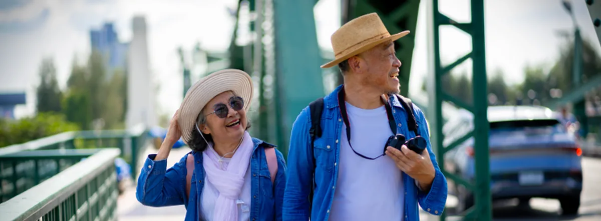 Retired couple taking pictures on bridge while travelling