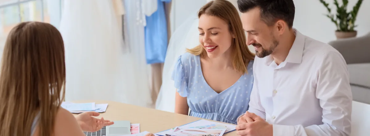 Couple reviewing budget for wedding with wedding planner