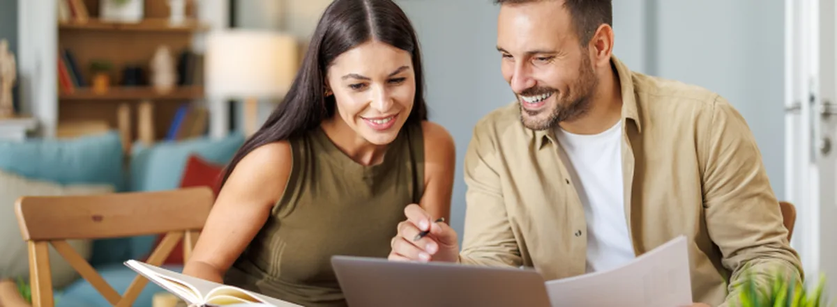 Couple filing income taxes together at kitchen table