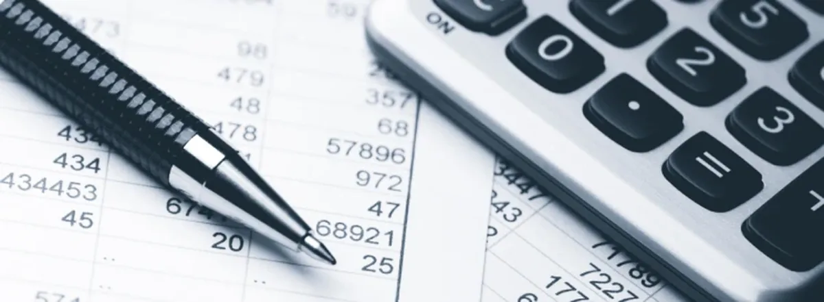 Financial spreadsheets, calculator and pen