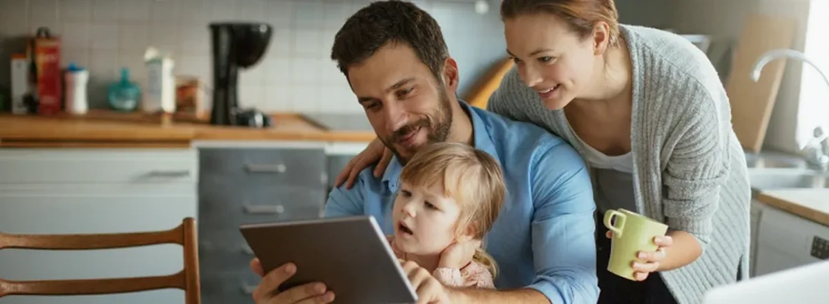 Family looking at tablet together and smiling