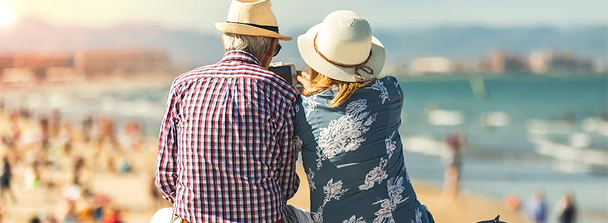 Couple wearing hats and sitting on the beach