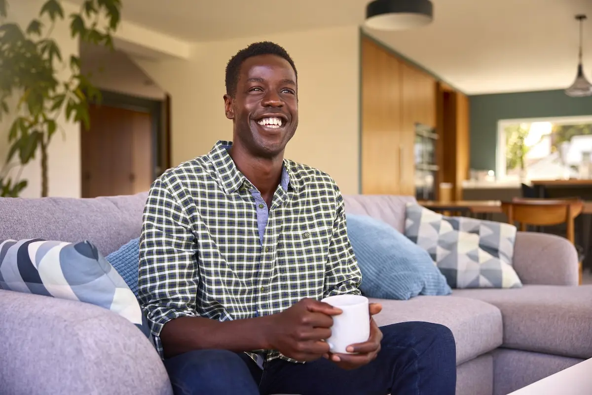 Young professional relaxing at home while managing everyday banking, illustrating the convenience and flexibility of modern chequing accounts for daily spending and bill payments.