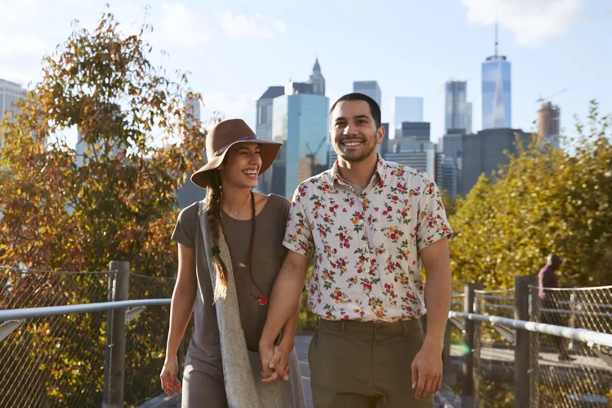 Couple visiting New York with Manhattan skyline in the background.