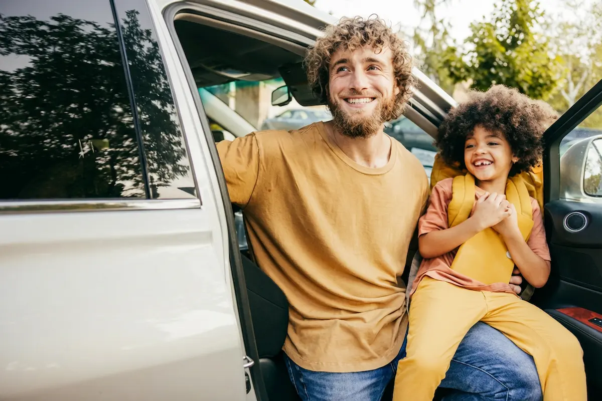 Father and daughter exiting the vehicle for school drop-off.