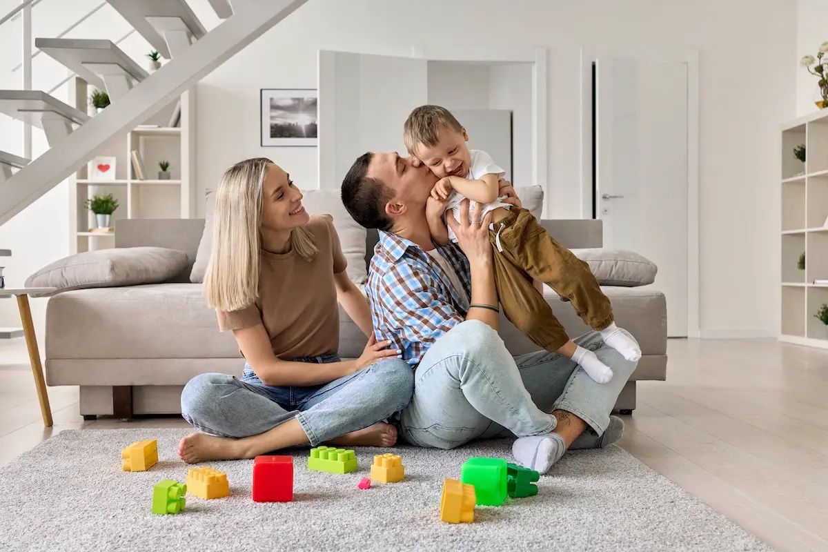 Happy young family with a boy child sitting on the floor.