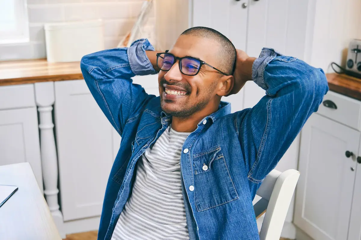 Man smiling and relaxing in the kitchen.