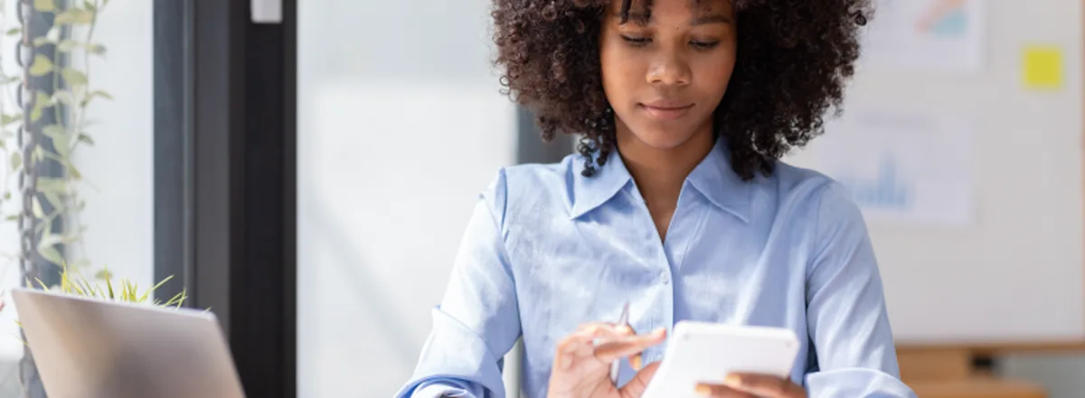 Woman doing calculations on calculator at desk