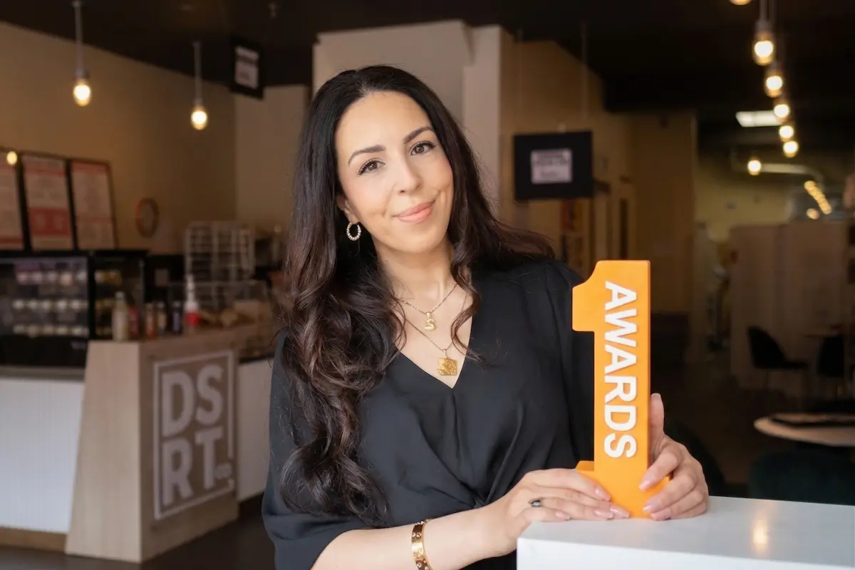 FirstOntario 1Awards winner standing inside a modern cafe.