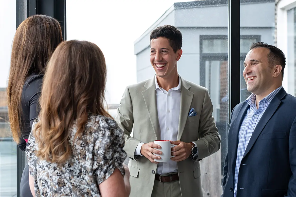 Colleagues chatting and networking in an office setting.