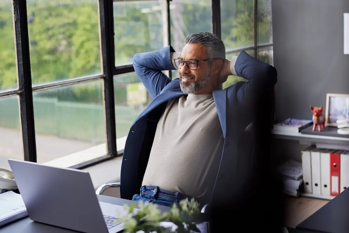 Mid adult business owner taking a break in his modern office.