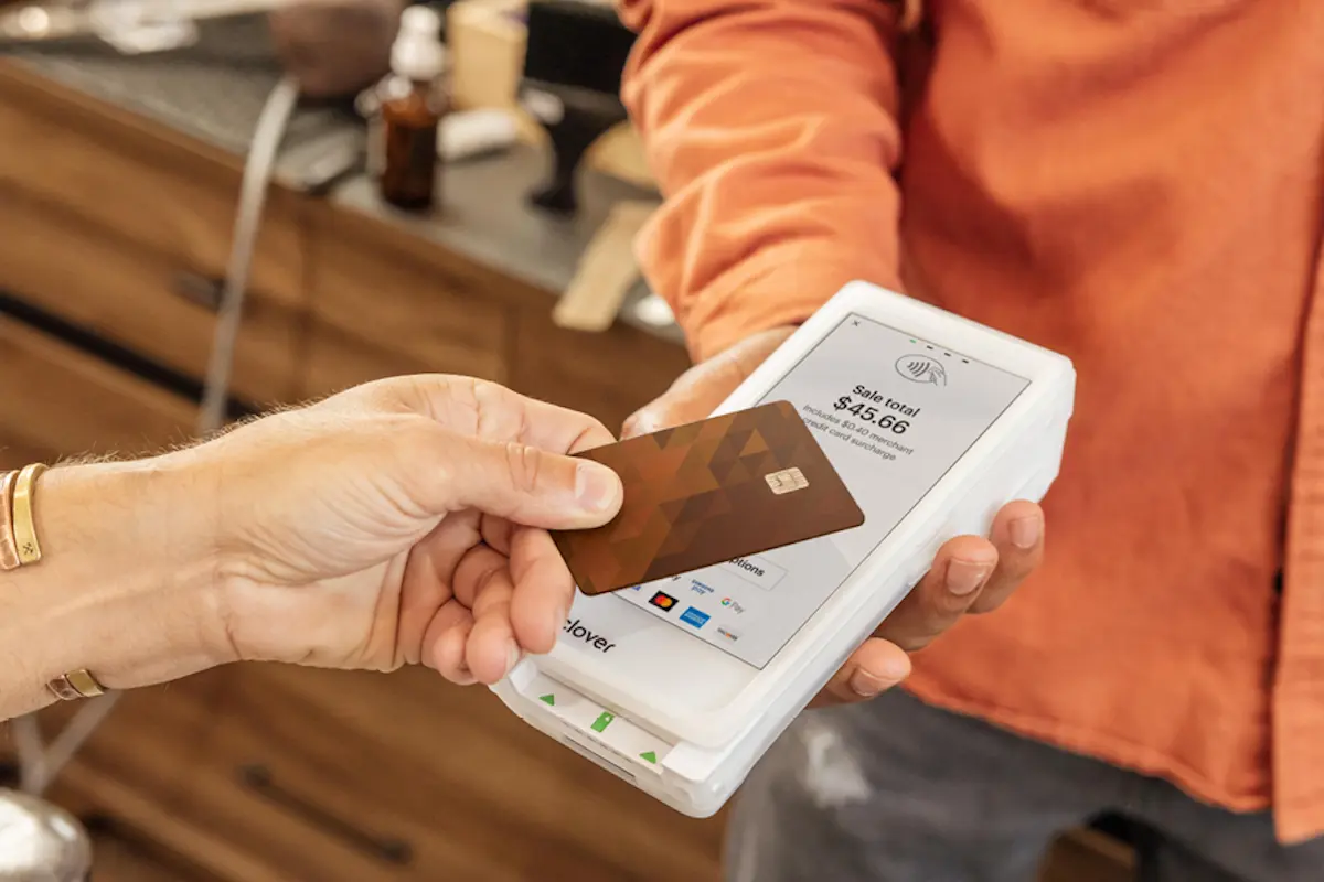 Customer making contactless payment with a credit card on the Clover terminal.