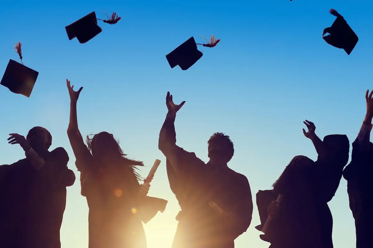 Graduates throwing caps after graduation ceremony.