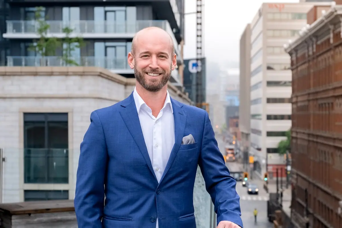 Business professional standing in a city, representing trusted financial partnership for condo communities.