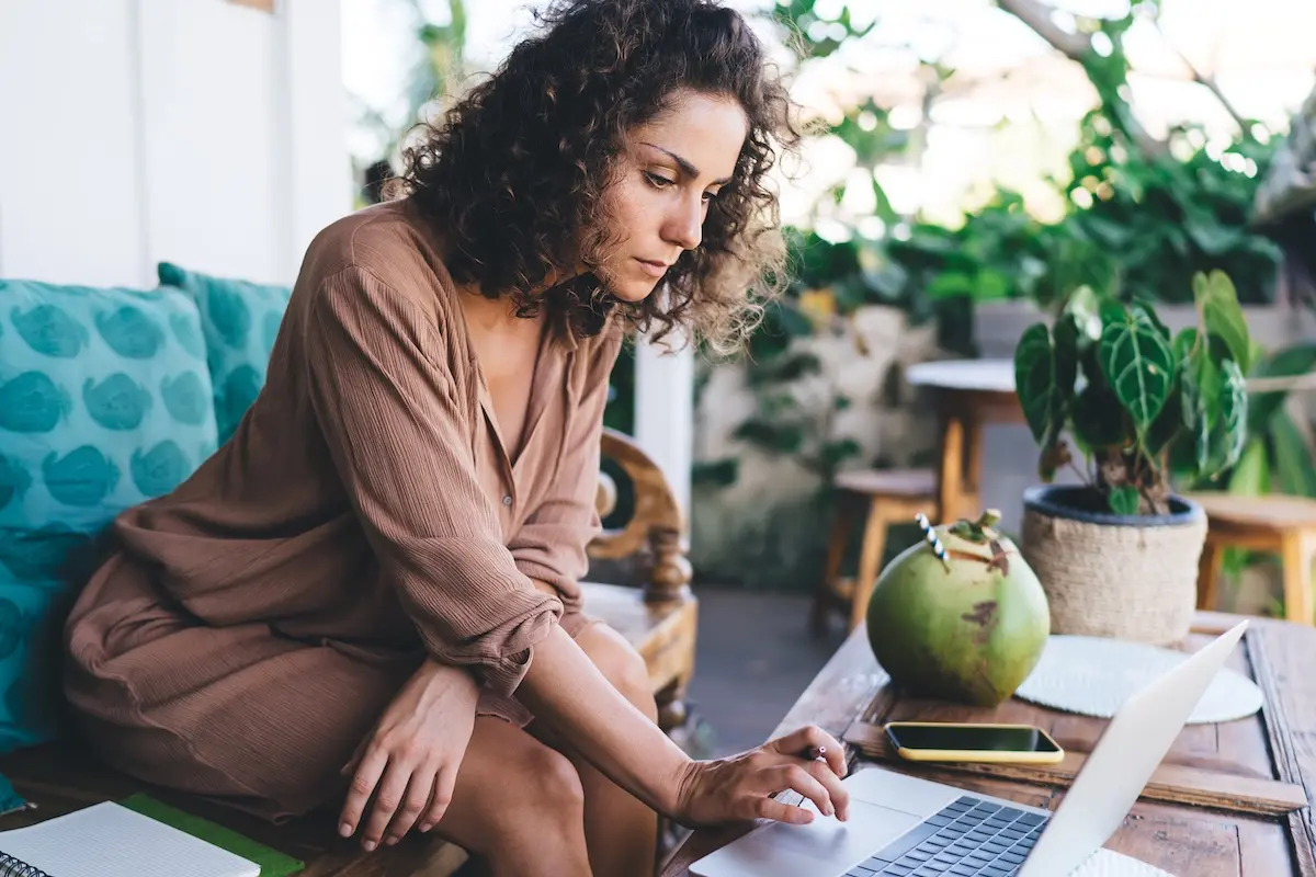 Small business owner working on a laptop from home, reviewing payments and business tasks.