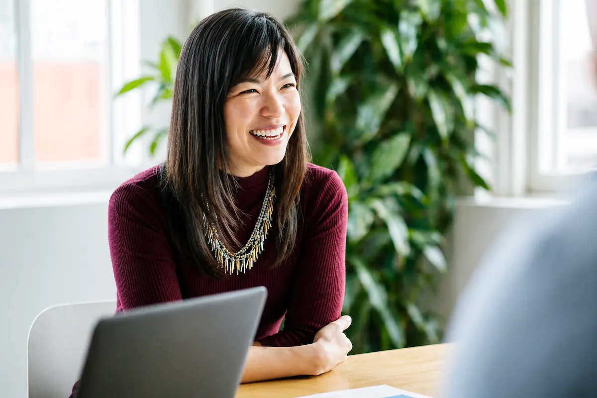 Customer service representative smiling while speaking with a member.
