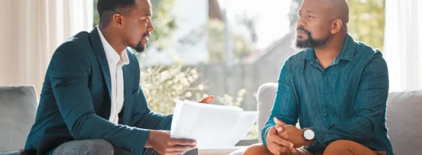 Two men reviewing documents in sunny office