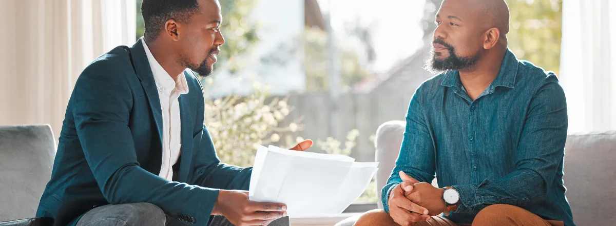 Two men reviewing documents in sunny office